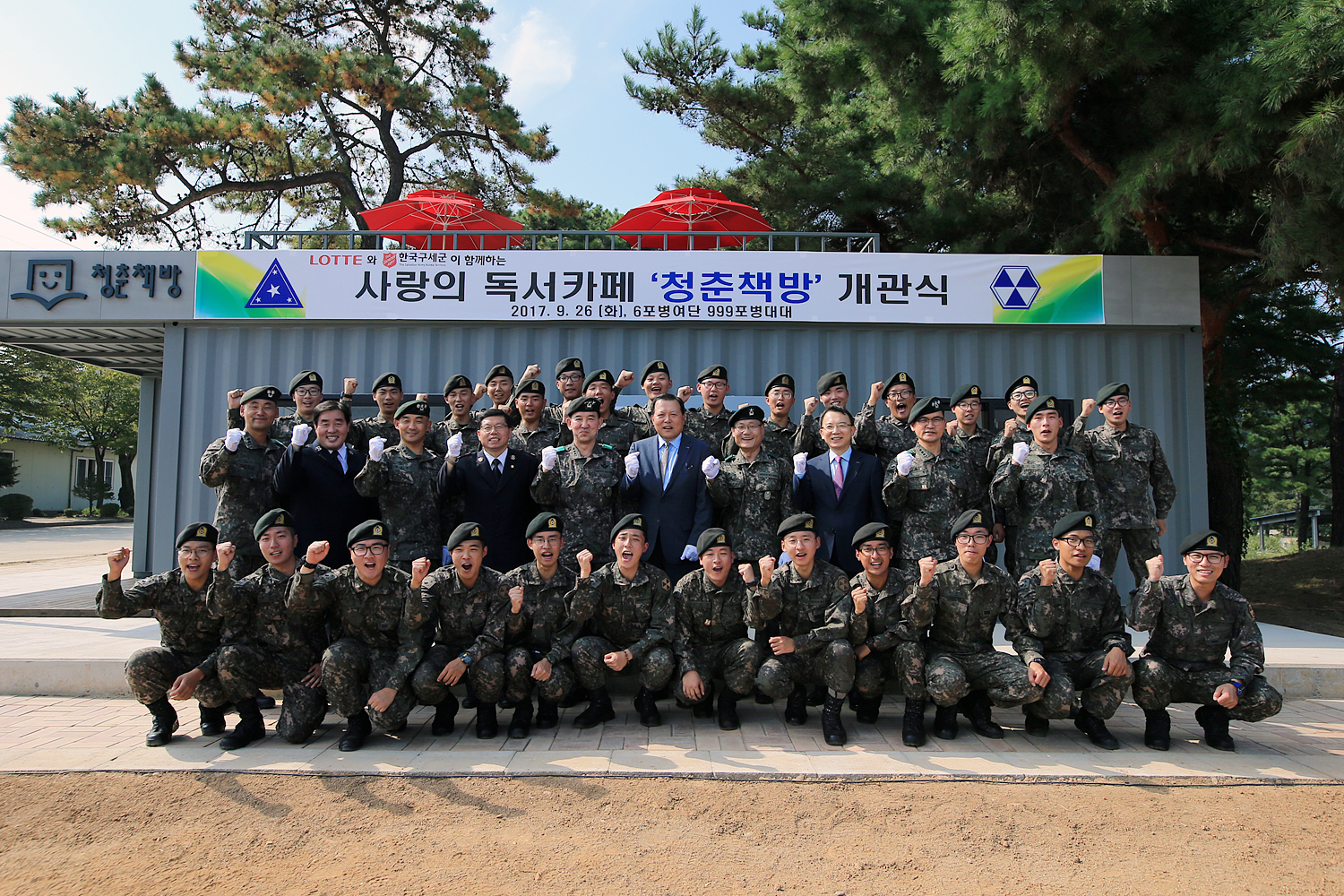 [롯데는 26일 경기도 연천 6군단에 '청춘책방' 12호점을 오픈했다. 사진은 개소식에 참석한 (두번째줄 왼쪽부터) 육군 999포병대대 공공호 대대장(중령), 한국구세군냄비본부 김기석 모금본부장, 육군본부 전성대 인사기획과장(대령), 한국구세군냄비본부 박희범 사회복지부장, 육군 김성진 제6군단장(중장), 롯데그룹 황각규 경영혁신실장(사장), 육군 박정택 6포병여단장(준장), 롯데그룹 오성엽 커뮤니케이션팀장(부사장), 육군 이현 6포병단장, 육군 김강수 병장과 999포병대대 장병들이 기념촬영을 하는 모습]
